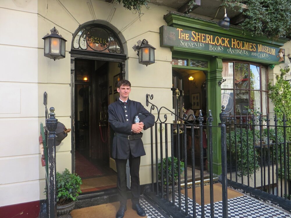Вход в Музей Шерлока Холмса охраняет костюмированный полицейский. Справа — вход в магазин сувениров