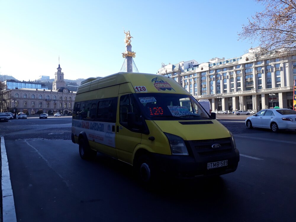 A yellow shuttle bus on Liberty Square