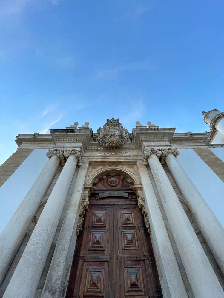 Колонны, тяжелые деревянные двери и лепнина — отличительные черты старейшего университета Португалии.